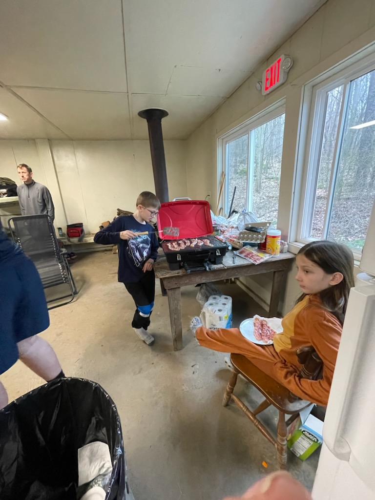 Scouts cooking and eating breakfast